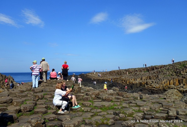 Crowds of tourists climb the rocks