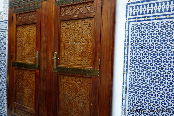 Beautifully carved doors lead into a side room and blue and white tile work
